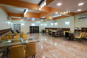 a large room with tables and chairs in it at Collection O RIVERIA RESORT in Noida