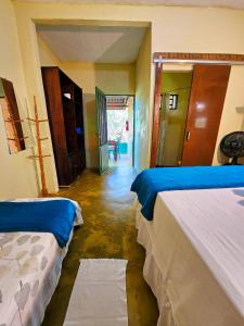 um quarto com duas camas e um corredor em Canto da Coruja - ECOHOSPEDAGEM em Sao Jorge