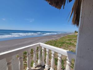 uitzicht op het strand vanaf het balkon van een huis bij Rancho Hostal Mar in Sonsonate