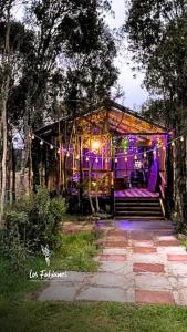 a house with a gazebo with purple lights at Cabañas Los Fabianes in Castro