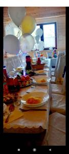 stół z talerzami jedzenia i balonami na nim w obiekcie Domki Letniskowe oraz Chata Grillowa " Nad Zalewem "Bliżyn w mieście Bliżyn