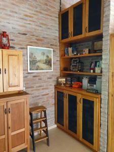 cocina con armarios de madera y taburete en una habitación en Dormitorio con baño privado, cocina y living compartido con pileta en country en Pergamino
