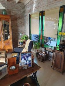 sala de estar con sofá y mesa en Dormitorio con baño privado, cocina y living compartido con pileta en country en Pergamino