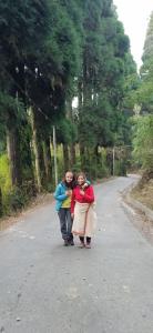 two people walking down a road in the street at Yuven House in Darjeeling