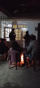 eine Gruppe von Personen, die in einem Zimmer auf Stühlen sitzen in der Unterkunft Yuven House in Darjeeling