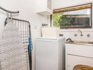 uma cozinha com uma máquina de lavar roupa e um lavatório em Walk to the MCG - Renovated House with back yard em Melbourne