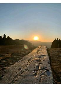 a view of the sun setting over a road at Yuven House in Darjeeling