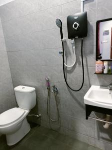 a bathroom with a shower and a toilet and a sink at The Marak Village KB - Mini Homestay in Kota Bharu