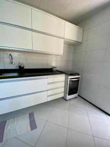 cocina con fregadero y fogones en Casa de praia 250 metros da praia, en Aracaju