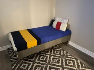 un piccolo letto in una stanza con un tappeto di Cozy 1.5 Guest-Suite a Aurora