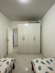 1 dormitorio con 2 camas y armarios blancos en Casa de praia 250 metros da praia, en Aracaju