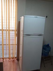 um frigorífico branco num quarto com uma janela em siberia 166 departamento 211 em Cidade do México
