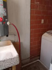 un tuyau rouge est fixé à un mur de briques dans l'établissement siberia 166 departamento 211, à Mexico