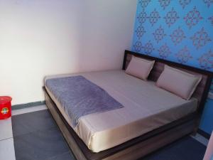 Bett in einem Schlafzimmer mit blauer Wand in der Unterkunft OYO Blue Dream Palace in Nārnaul