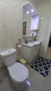 uma casa de banho com um WC branco e um lavatório. em Grand appartement 21 em Istambul