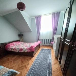 um quarto com 2 camas e uma janela com cortinas roxas em Grand appartement 21 em Istambul