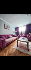 uma sala de estar com um sofá roxo e uma mesa de centro em Grand appartement 21 em Istambul