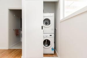 a laundry room with a washer and dryer at The Pavilion on Grossman's in Torquay