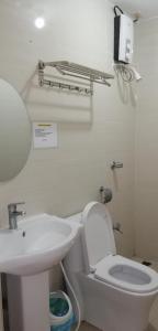 a bathroom with a white toilet and a sink at Meaco Royal Hotel - Biñan Laguna in Biñan
