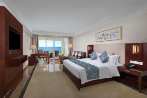 a hotel room with a bed and a living room at Wyndham Garden Wenchang Nanguo in Wenchang