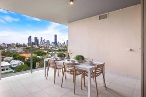 a dining room with a table and chairs on a balcony at Gabba Oasis:Luxury 3BRM Apt Pool in Brisbane