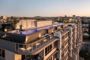 an apartment building with a swimming pool at dusk at Gabba Oasis:Luxury 3BRM Apt Pool in Brisbane