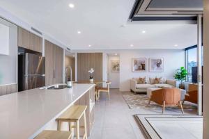 a kitchen and living room with a couch and a table at Gabba Oasis:Luxury 3BRM Apt Pool in Brisbane