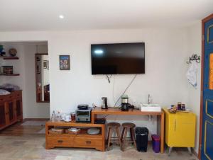 Habitación con escritorio y TV en la pared. en Solar dos Reis Apartamento Topázio en Ouro Preto