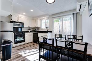 a kitchen with white cabinets and a table and chairs at Getaway near UO, Autzen Stadium, Amazon Park # 3 in Eugene