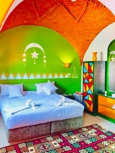a bedroom with a bed with a green wall at Horus Mini Resort in Cairo