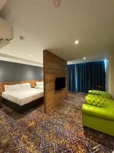 - une chambre avec un lit, un canapé et une télévision dans l'établissement Le'genda Hotel, à Kajang