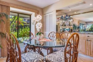 a dining room with a glass table and chairs at WAILEA ELUA, #2201^ condo in Wailea