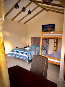 1 dormitorio con 1 cama y 1 silla en Cabañas Campestres Bosque Encantado, en Guatapé