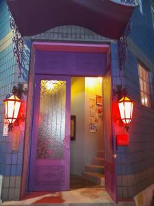 a purple door with two lights on a building at Deluna House in Mokpo