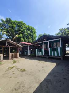 un grupo de edificios con árboles en el fondo en Cabañas en Playa la Barra, en Buenaventura