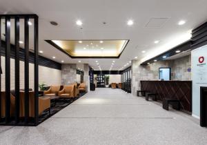 a lobby with chairs and a bar in a building at Daiwa Roynet Hotel Kobe Sannomiya in Kobe