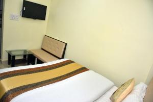 Habitación con cama, mesa y TV. en Hotel Us Residency en Kakarmatha