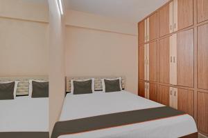 a bedroom with a bed and wooden cabinets at Collection O Ns Service Apartment in Tirupati