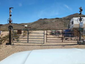 a gate to a rv in front of a mountain at Top Camp Sites at Desert Gardens Oasis at Lobo, Texas 
