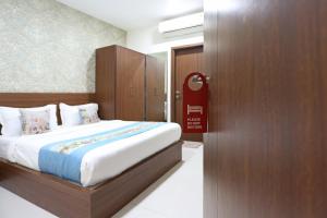 a bedroom with a large bed and a wooden door at Super Capital O Hotel Swastika in Jaipur