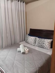 a bed with a pair of socks and a cup on it at Shell Residences in Manila