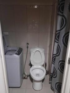 a small bathroom with a toilet and a shower at Shell Residences in Manila