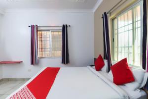 een slaapkamer met een groot wit bed met rode kussens bij Super Capital O Hotel The Tulip in Rānchī