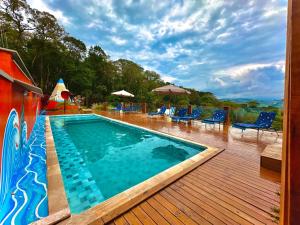 布埃諾布蘭的住宿－Castelo Excalibur, Vila Mágica，一个带椅子的木制甲板上的游泳池