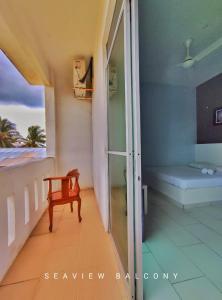 a room with a balcony with a bed and a window at AQIL BEACH INN in Marang