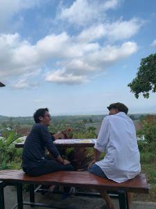 two men sitting on a bench looking out at the view at Balelangga Bed & Breakfast in Sapit