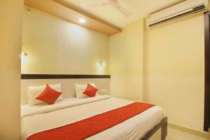 1 dormitorio con 1 cama con almohadas rojas en Hotel Rj Grand, en Coimbatore
