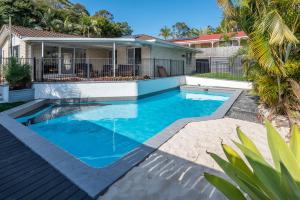 a swimming pool in front of a house at Family Escape - Serene Oasis with Pool and AC in Brisbane