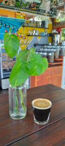 um vaso de vidro com uma planta e um copo sobre uma mesa em Balelangga Bed & Breakfast em Sapit