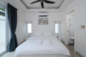 a white bedroom with a bed and a ceiling fan at Orchid Paradise Homes OPV 210 in Hua Hin +31 photos